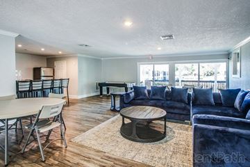 Tampa apartment for rent - a living room with blue couches and a table and chairs