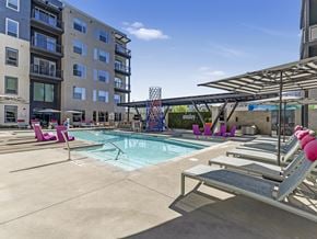 Las Vegas apartment for rent - A pool area with lounge chairs and a building in the background.