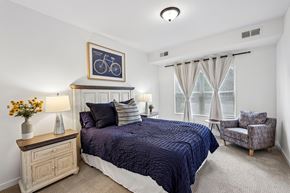 Blaine apartment for rent - A bedroom with a bed, chair, and a picture of a bicycle on the wall.