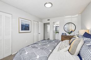 Jacksonville apartment for rent - A bedroom with a large bed and a picture on the wall.