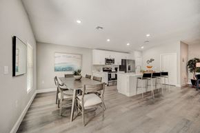 Lady Lake apartment for rent - Dining room and kitchen with a table and chairs at The Groves at Lake Ella in Lady Lake, Florida, a pet-friendly rental community.