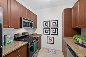 Woodbridge apartment for rent - A kitchen with brown cabinets and a black stove top oven.