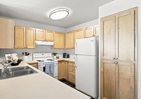 Coeur D Alene apartment for rent - A kitchen with wooden cabinets and a white refrigerator.