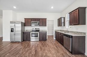 Lakeland apartment for rent - A kitchen with dark brown cabinets and a stainless steel refrigerator.