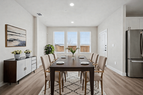 Melissa townhouse for rent - A dining room with a table set for six and a view of the outdoors through the windows.