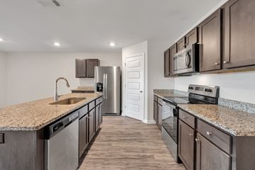 Ocean Springs apartment for rent - A kitchen with brown cabinets and a granite countertop.