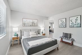 Phoenix apartment for rent - One-Bedroom Apartments in North Mountain Village, Phoenix, AZ - Ardella on 28th - Spacious Bedroom With Upholstered Bed, Side Tables, Lamps, Soft Gray Bedding, Bed Bench, and Large Window With Blinds.