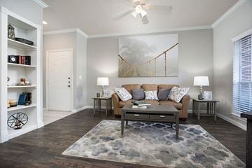 Houston apartment for rent - A living room with a couch, a rug, and a painting on the wall.