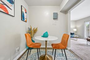 Raleigh apartment for rent - A dining room with a white table and orange chairs.