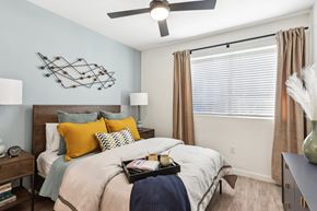 Henderson apartment for rent - A bedroom with a bed, a ceiling fan, and a wall art.