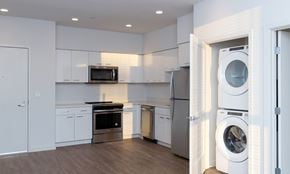 Oakland apartment for rent - A modern kitchen with white cabinets and appliances.