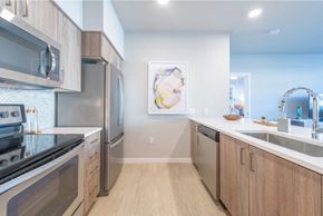 Tigard apartment for rent - a kitchen with wooden cabinets and stainless steel appliances