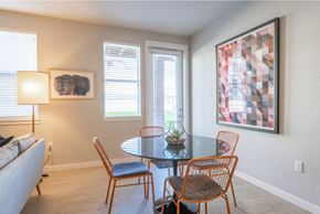 Tigard apartment for rent - Apartments for Rent in Tigard - Sygnii - Dining Area with Round Glass-Top Dining Table, Four Metal-Framed Chairs, and Floor Lamp.