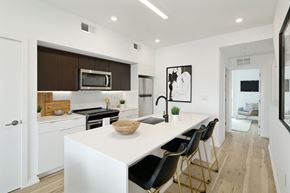 Philadelphia apartment for rent - A modern kitchen with white countertops and black chairs.