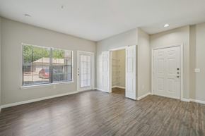 San Antonio apartment for rent - A spacious room with wood flooring and white walls.