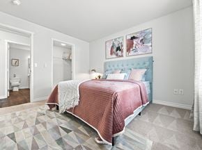 Coeur D Alene apartment for rent - A bedroom with a bed covered in a pink blanket.