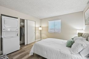Phoenix apartment for rent - A white bedroom with a bed, a refrigerator, and a window with blinds.