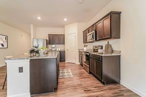 Locust Grove apartment for rent - A kitchen with dark brown cabinets and a black refrigerator.