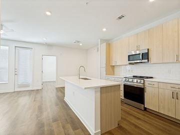 Allen apartment for rent - A kitchen with wooden cabinets and a white island.