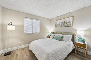 Phoenix apartment for rent - A bedroom with a bed, nightstand, and lamp.