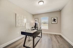 Lady Lake apartment for rent - Spacious office area with a desk, chair, and large window at The Groves at Lake Ella in Lady Lake, Florida, a pet-friendly rental community.