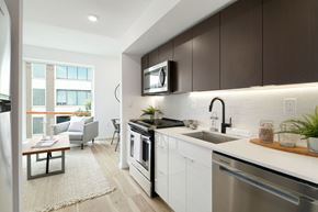 Philadelphia apartment for rent - A modern kitchen with dark brown cabinets and stainless steel appliances.