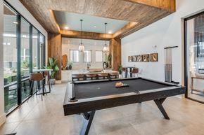 Waco apartment for rent - A pool table is in the middle of a room with a wooden ceiling.