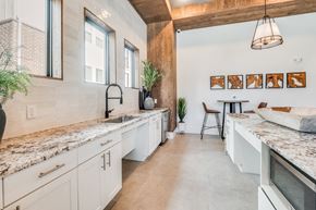 Waco apartment for rent - A kitchen with white cabinets and a marble countertop.