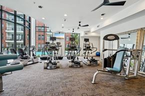 Houston apartment for rent - A gym with a variety of equipment including treadmills, weights, and exercise machines.