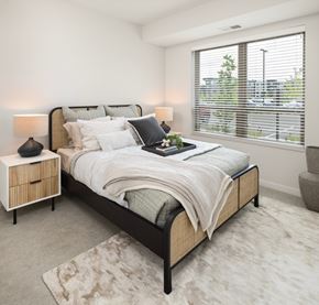 Coon Rapids apartment for rent - A bedroom with a large bed and a window with blinds.