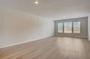 Charlotte townhouse for rent - A spacious room with wooden flooring and a window with blinds.