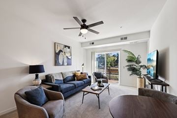 Blaine apartment for rent - A living room with a blue couch and a ceiling fan.