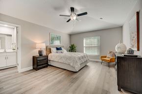 Lady Lake apartment for rent - Bedroom with a bed and ceiling fan at The Groves at Lake Ella in Lady Lake, Florida, a pet-friendly rental community.