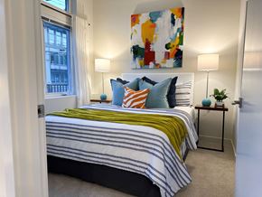 Bothell apartment for rent - 1-Bedroom Apartments in Bothell, WA - Morado Bothell - Bedroom with Carpeted Flooring, Bed, Nightstands, Nightstands with Lamps, Wall Art, and Large Window.