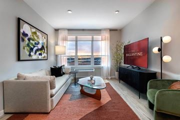 Newark apartment for rent - A living room with a red carpet and a large window.
