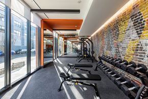 Newark apartment for rent - A gym with a brick wall and a row of exercise equipment.