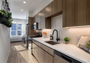 Newark apartment for rent - A modern kitchen with wooden cabinets and a white countertop.