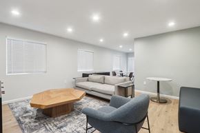 Fremont apartment for rent - A modern living room with a grey sofa, a wooden coffee table, and a grey armchair.