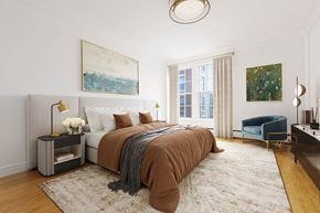 Brookline apartment for rent - Bright, modern bedroom with a large bed, blue armchair, and abstract artwork.