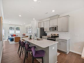 Raleigh apartment for rent - Modern open-concept kitchen with island and living room at The Maple 3-bedroom townhomes in Raleigh NC