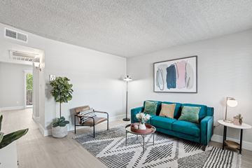Phoenix apartment for rent - A living room with a blue couch and a painting on the wall.