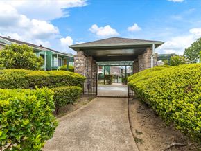 Houston apartment for rent - the entrance to a building with bushes and a walkway