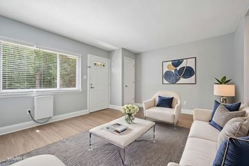 Raleigh apartment for rent - A living room with a white couch, a grey coffee table, and a painting on the wall.