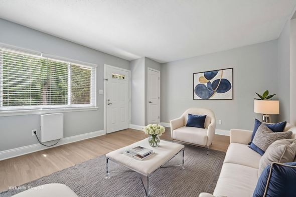 Raleigh apartment for rent - A living room with a white couch, a grey coffee table, and a painting on the wall.