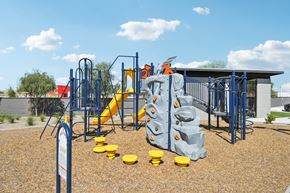 Tolleson apartment for rent - A playground with a blue and yellow slide and climbing structure.