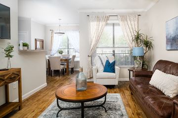 Houston apartment for rent - A living room with a brown leather couch and a wooden coffee table.