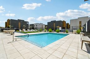 Tolleson apartment for rent - A pool surrounded by a tiled patio and lounge chairs.