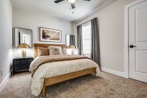 Melissa townhouse for rent - A bedroom with a bed, two lamps, and a painting on the wall.