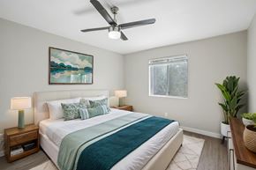 Tempe apartment for rent - A bedroom with a bed, a ceiling fan, and a painting on the wall.