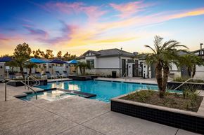 Phoenix apartment for rent - Phoenix AZ Apartments - The Crofton at Sheely Farms - Large Pool with a Hot Tub, Fountains, Plant Beds, Poolside Lounge Chairs, and Umbrellas, Shot at Sunset